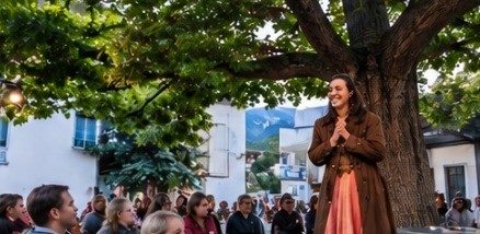 Sängerin auf dem Stadtplatz vor Publikum unter einem Baum